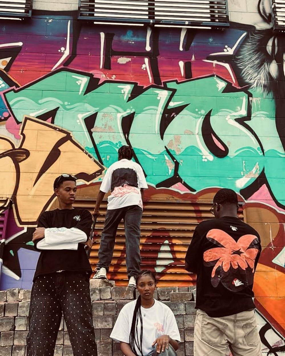 L'équipe VIBZ devant un mur de graffitis
